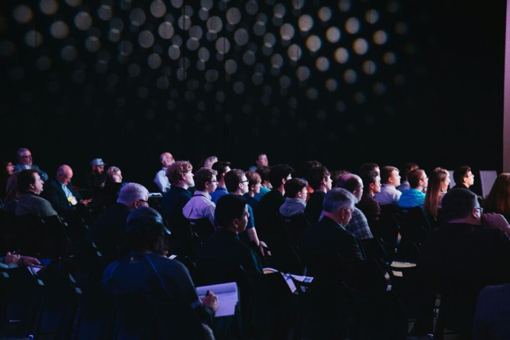 people watching a talk at a conference